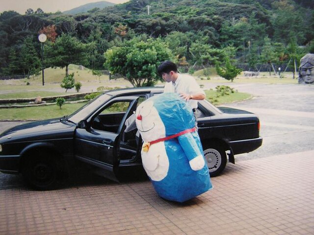 Doraemon visits Niijima High School. A moyai sits in the upper right of the photo.