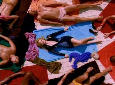 A still from the video, showing Minogue wearing a dark blue bodyhugging Balenciaga dress