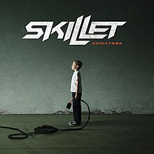 Et bilde av en gutt som holder en plugg i en tunnel med "Skillet - Comatose" over gutten.