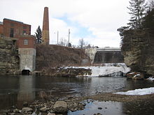 The Upper "Junction Falls" Dam on the Kinnickinnic River in River Falls, Wisconsin as it appears today. The Historic Junction Falls are obscured by its presence, the lowest ledge of the Junction Falls now sits as the dry ledge below the base of the dam. Upper "Junction Falls" Dam on the Kinnickinnic River, River Falls, Wisconsin.jpg