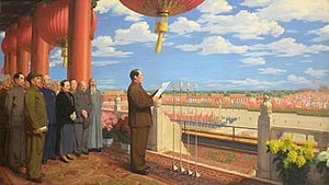 Mao se encuentra en un balcón con vistas a la Plaza de Tiananmen.  Lee un discurso con otros líderes reunidos detrás de él.
