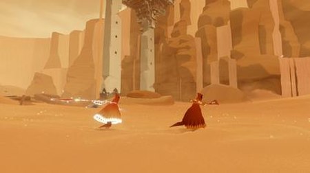 The robed figure running in the desert along with another player's figure. One of the figures' scarves is glowing as it charges due to proximity to th