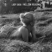 Lady Gaga lies in a field of grass in this black and white photograph.