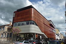 Photographie d'un bâtiment moderne gris et marron.