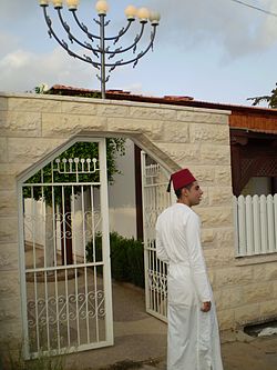 שומרוני מול שער כניסה חדש לבית הכנסת הקטן בנווה פנחס