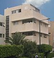 חזית בניין בסגנון הבינלאומי בתל אביב עם קרניזים מעל החלונות