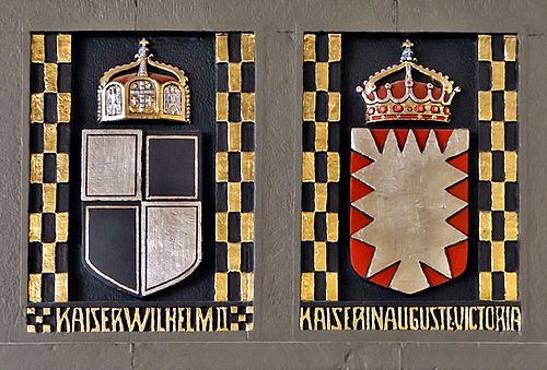 הסמלים ההראלדיים של וילהלם השני ואוגוסטה ויקטוריה על אח באולם הצמוד לכנסיית אוגוסטה ויקטוריה בירושלים