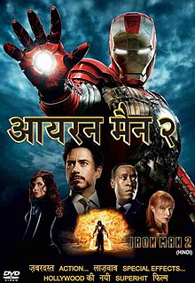 Tony Stark is pictured center wearing a smart suit, against a black background, behind him are is the Iron Man red and gold armor, and the Iron Man silver armor. His friends, Rhodes, Pepper, are beside him and below against a fireball appears Ivan Vanko armed with his energy whip weapons.