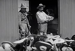 Pancho Villa egy teherkocsiban állva kukoricát oszt az embereknek