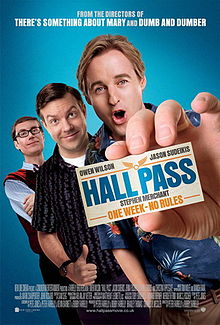Man holding up a card labelled hall pass, his friends standing behind him