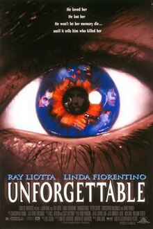 Closeup image of an eye, the iris is blue and flecked with red, an image of a man holding a gun is can be seen in the iris, the face of another man is reflected in the dark pupil