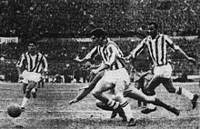 Mazzia (a sinistra) in azione alla Juventus nel 1962, assieme ai compagni di maglia Leoncini e Charles, nel corso della sfida di Coppa dei Campioni contro il Real Madrid.