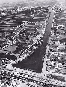 Veduta aerea della darsena di Ravenna nel 1960, in basso la stazione con i vecchi raccordi verso le industrie del canale