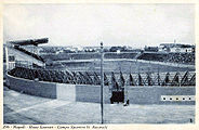 Panoramica dello stadio con in primo piano gli spalti in legno.