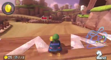 Baby Luigi che guida sul kart GLA nella pista N64 Valle di Yoshi