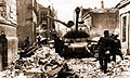 Vērmahta karavīri Katoļu ielā ar sašauto tanku