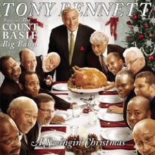 Tony Bennett standing at the head of the table during a holiday meal gathering of over a dozen men as the turkey arrives.