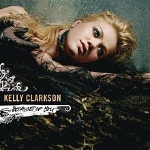 Uma imagem de uma mulher usando roupas pretas luminosas deitada com a sua cabeça apoiada em seu braço esquerdo olhando para o lado. Ao lado dela, as palavras "Kelly Clarkson" e "Because of You" estão escritas em letras maiúsculas nas cores amarelo e preto, respectivamente.