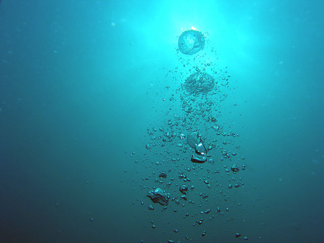 Пузыри, поднимающиеся из акваланга, на фоне солнца