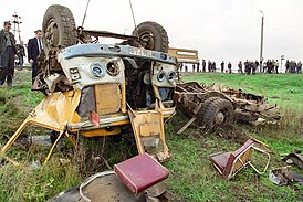 De bus, onherkenbaar verminkt, na een aanrijding met een diesellocomotief