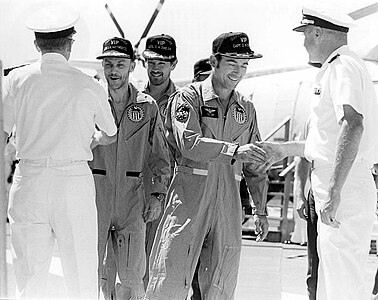 Высокие чины ВМФ США приветствуют Маттингли, Дьюка и Янга (слева направо)