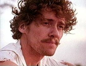 John Holmes como Joe Murray en Prisionero del paraíso