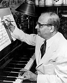 Greyscale photograph of Max Steiner with a piano