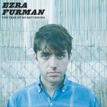 Ezra Ferman u plavoj košulji stoji ispred sive ograde i gleda u kameru dok joj krvari nos