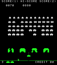 A vertical rectangular video game screenshot that is a digital representation of a battle between aliens and a laser cannon. The white aliens hover above four green, inverted U-shaped blocks. Below the blocks is a smaller horizontal block with a triangle on its top.