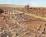 A picture of a city ruins and a still-standing building near the back.