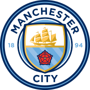 A rounded badge depicting a shield containing a ship, the Lancashire Rose، and the three rivers of Manchester.