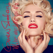 A photograph displaying Gwen Stefani wearing a navy top whilst her hands touch her face. The title of the song is shown in a red, cursive script.