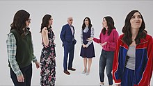 From left to right, a Janet in Chidi's clothes, a Janet in Tahani's clothes, Michael, the real Janet, a Janet in Eleanor's clothes, and a Janet in Jason's clothes