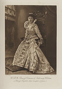 Black-and-white photograph of a seated woman richly dressed in a historical costume