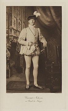 Black-and-white photograph of a standing man richly dressed in an historical costume